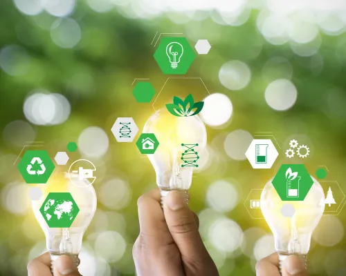 Hands holding light bulbs with sustainability icons